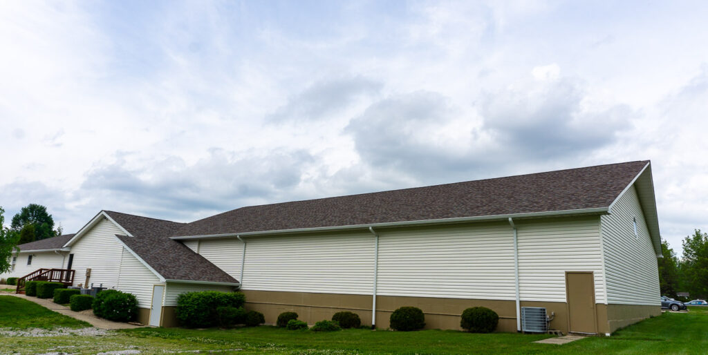 Rear view of McCormick's Creek Church, highlighting the building and surrounding green area.