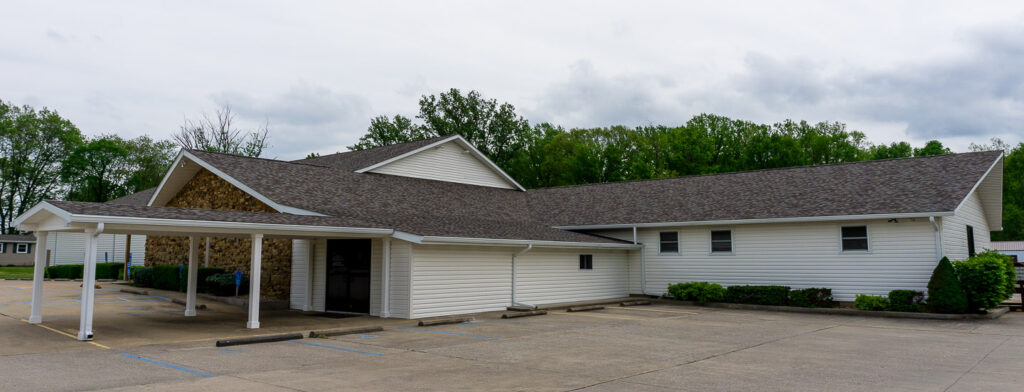 Front view of McCormick's Creek Church building with a cross on the wall.