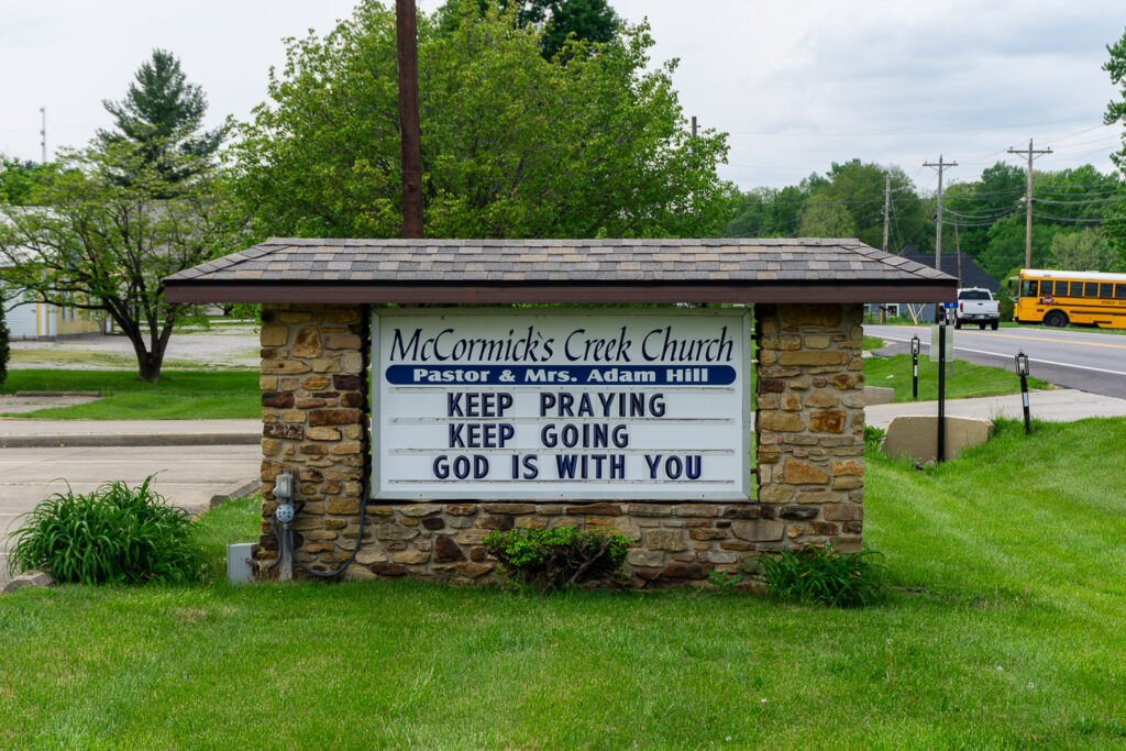 Church sign for McCormick's Creek Church in Spencer, Indiana, displaying the message "Keep praying, keep going, God is with you."