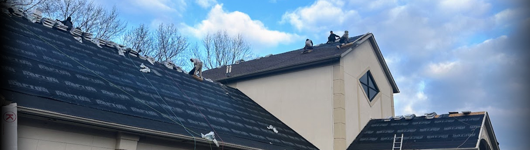 Roofing team repairing a church roof in Bloomington with underlayment visible and shingles removed.