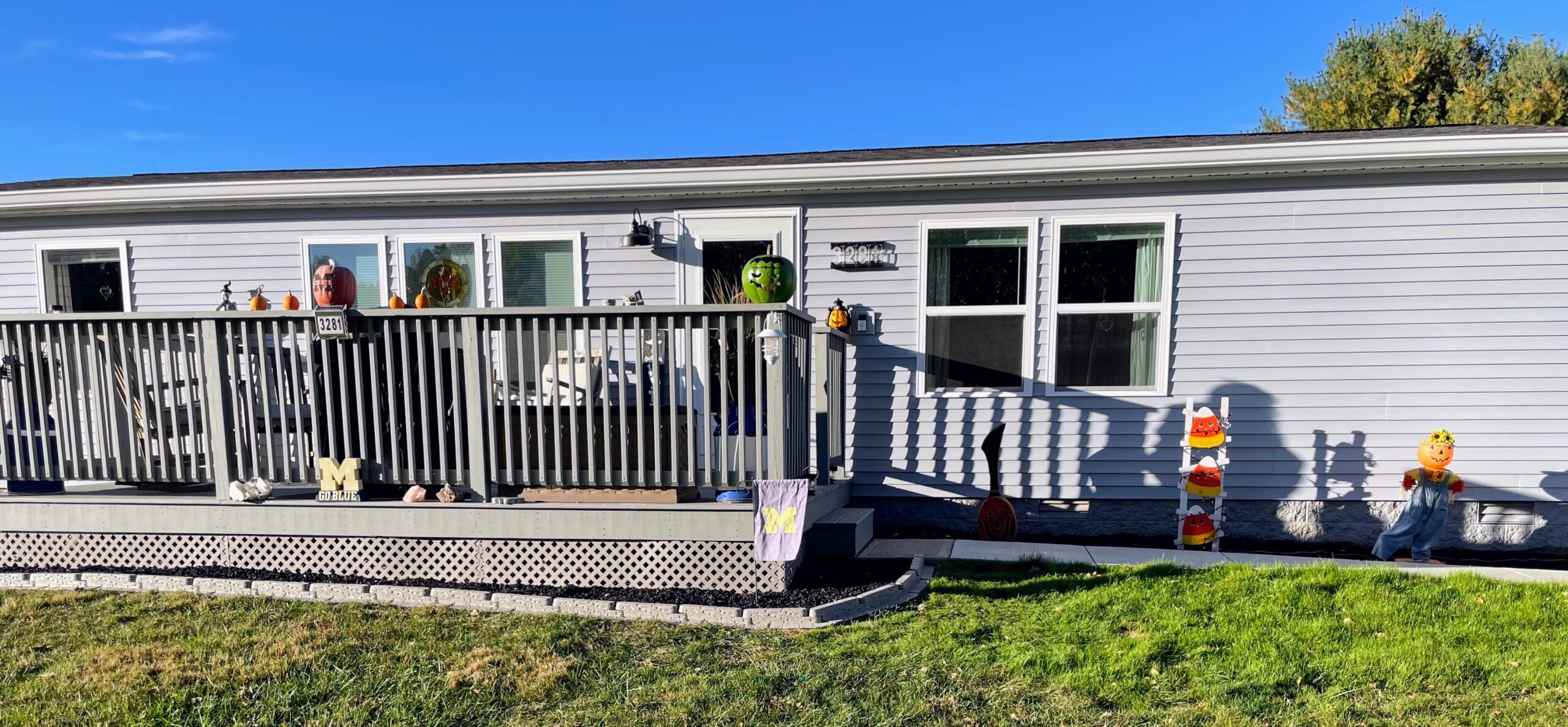 Newly installed siding on a residential home with festive decorations on the front deck.